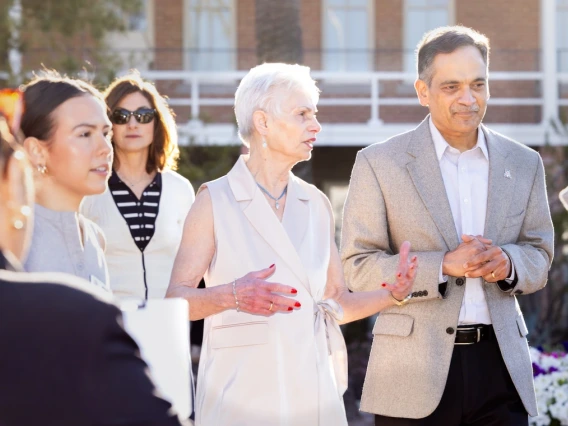 President Garimella standing and speaking with Pat Gerleman and other staff members in front of Old Main 