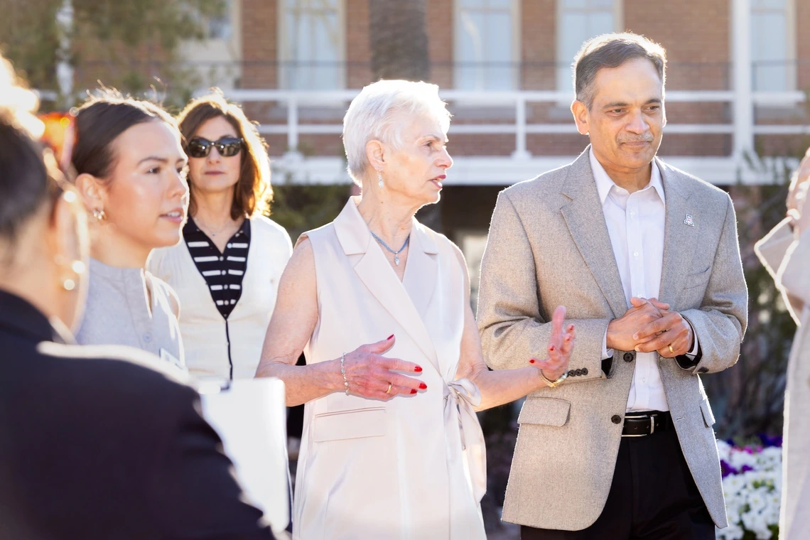 President Garimella standing and speaking with Pat Gerleman and other staff members in front of Old Main