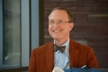 A man wearing a bow tie smiling