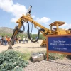 A group of people looking at an excavator behind a sign that says, "San Xavier Mining Laboratory."
