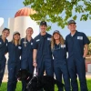 6 vet med students smile on farm with leashed black lab 